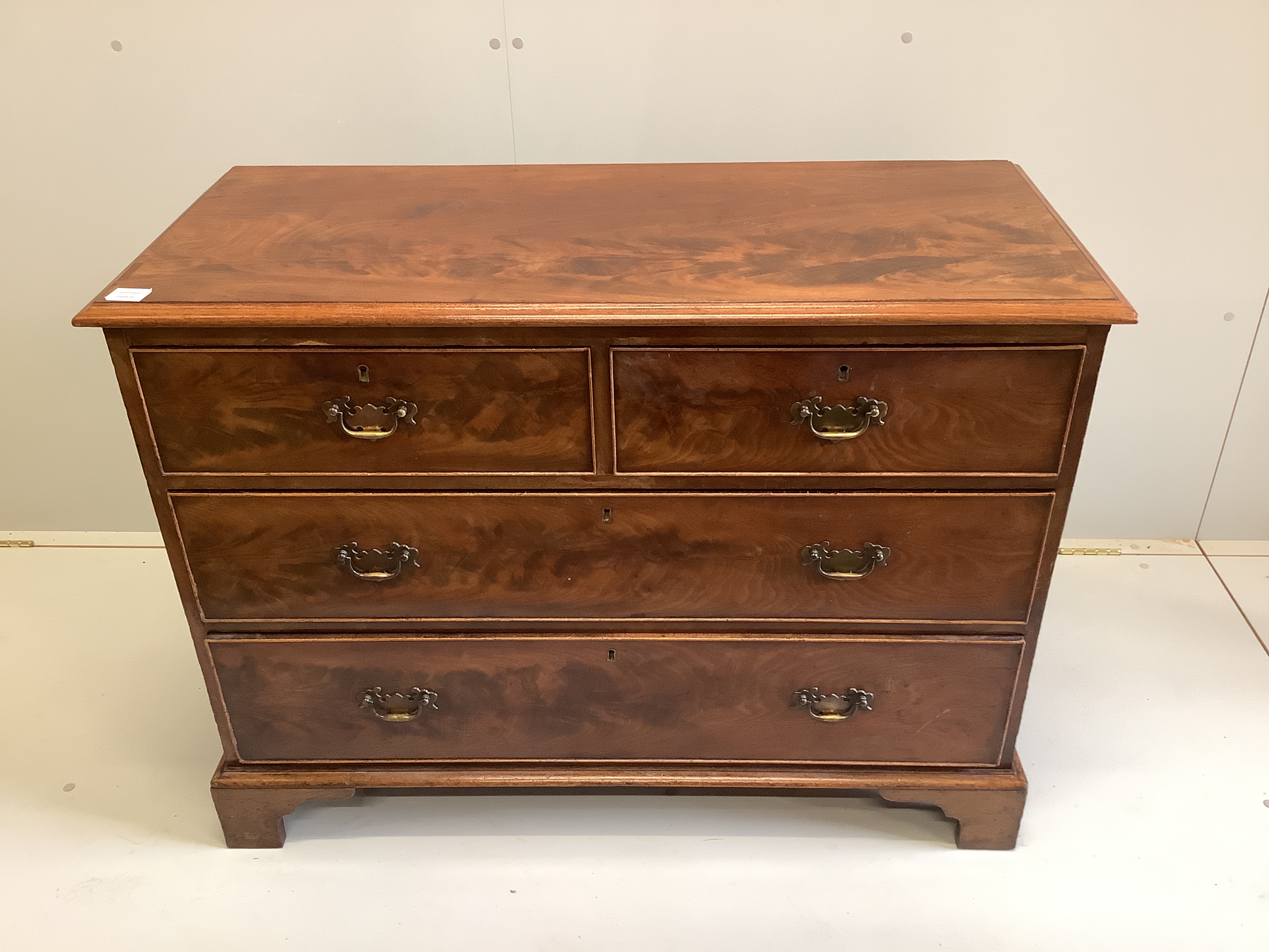 A George III mahogany chest of two short and two long drawers, raised on bracket supports, width 106cm, depth 47cm, height 79cm